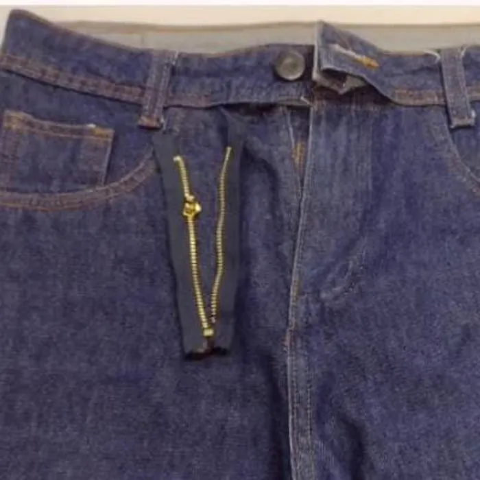 Calça jeans com o zíper antigo rasgado, antes da troca